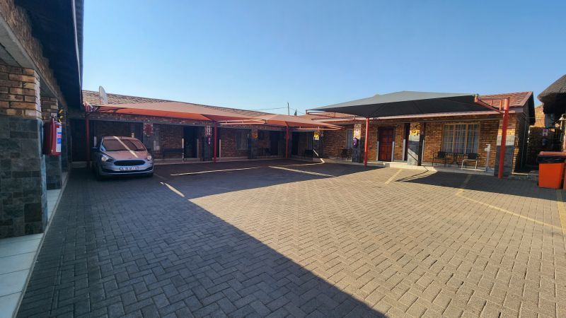 A car is parked in a parking lot in front of a building.