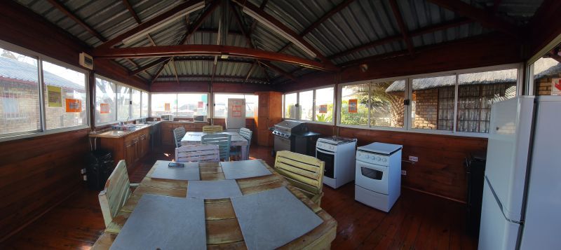 A kitchen with a table , chairs , stove and refrigerator.