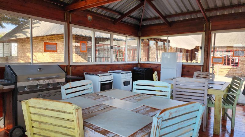 A dining room with tables and chairs and a grill.