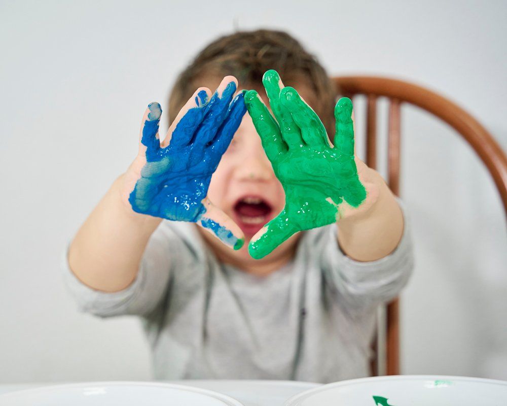 Boy With Blue And Green Paint On Hand — Cheyenne, WY — I Am A Promise Daycare