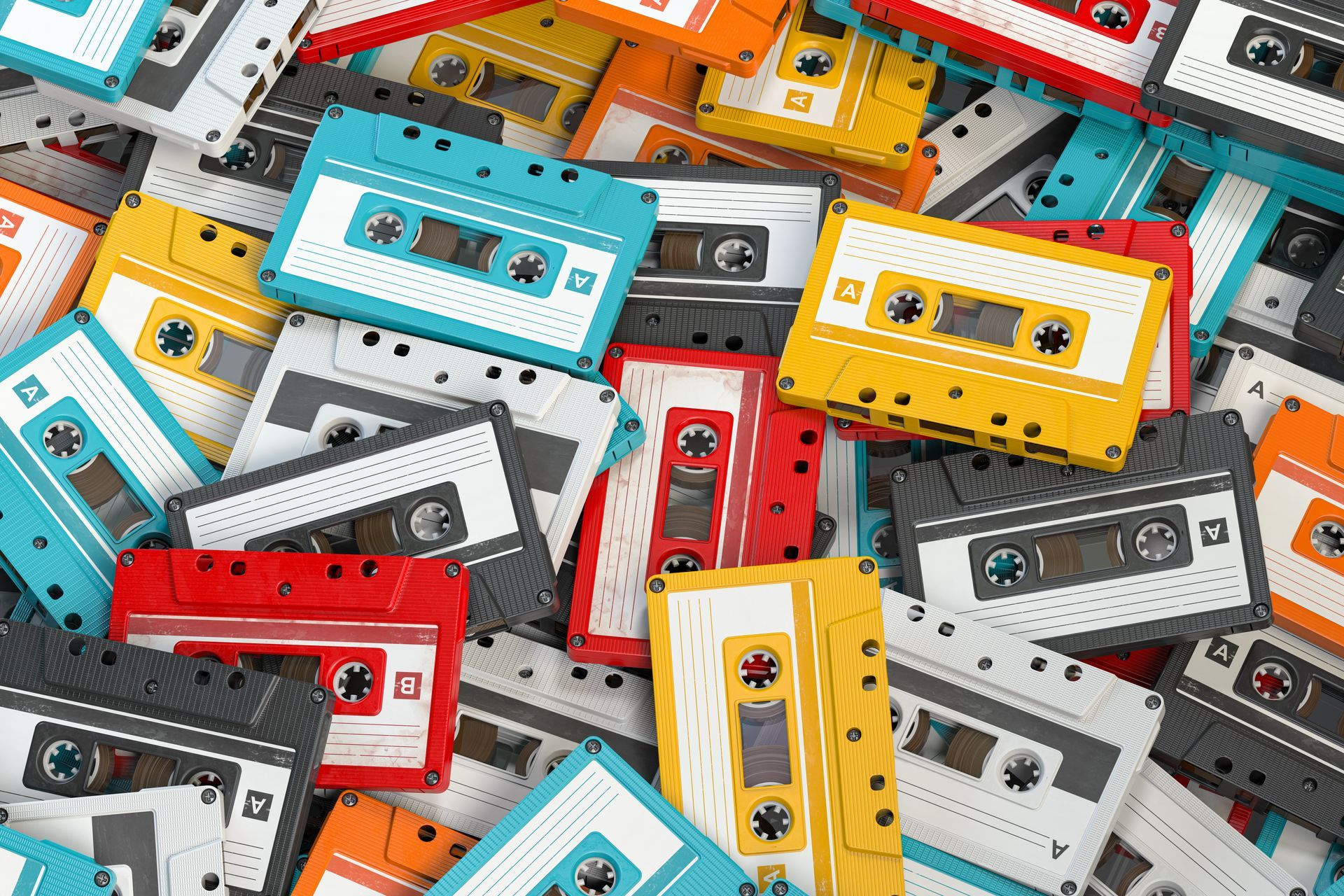 A pile of cassette tapes of different colors are stacked on top of each other.