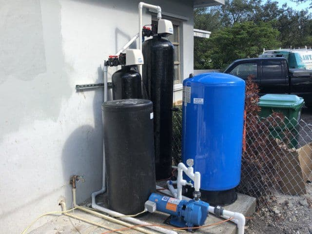 A blue tank is next to a black tank on the side of a building