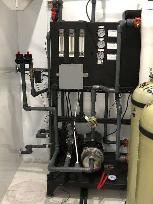 A room with a lot of pipes and a black box