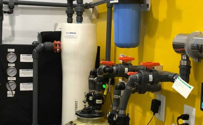 A room with a lot of pipes and a yellow wall.