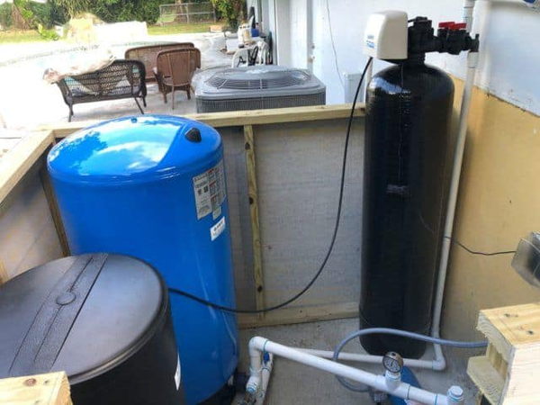 A blue tank is sitting next to a black tank in a room.