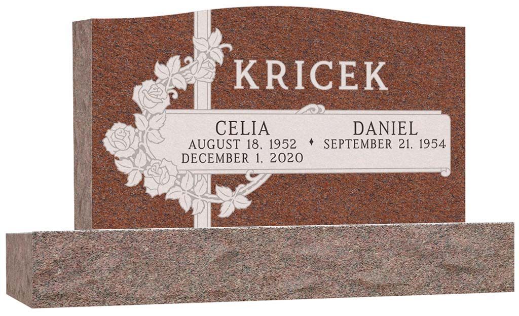 Red granite memorial bench with engraved family names and white floral engraving