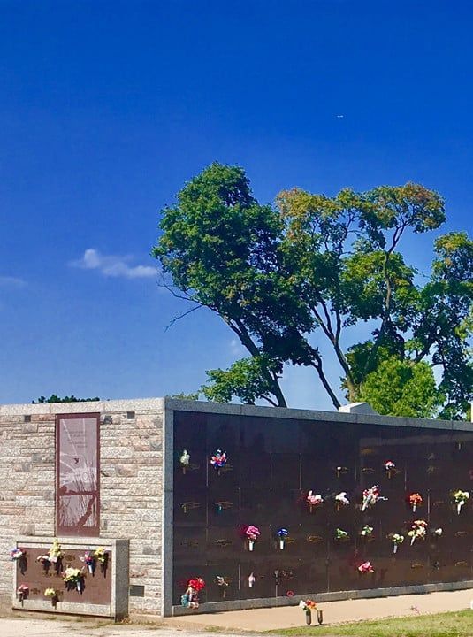 A large wall with flowers on it in a cemetery