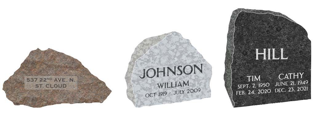 Three engraved stone markers, brown, gray, and black, arranged side by side.