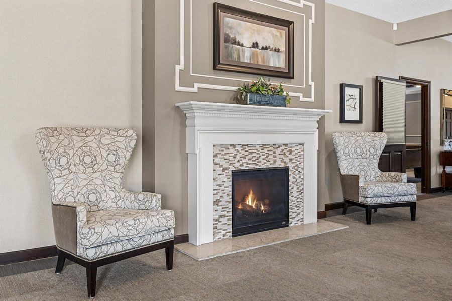 A living room with two chairs and a fireplace.