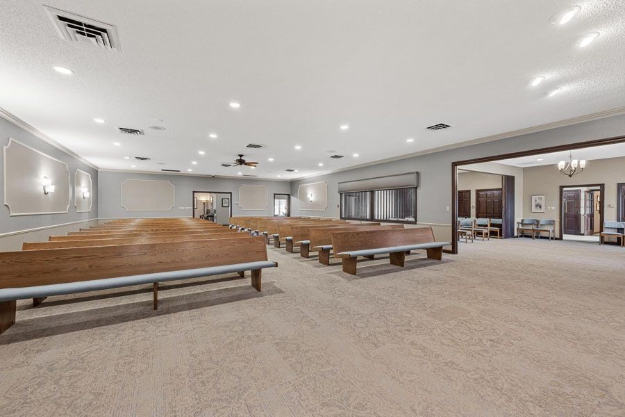 A large empty church with wooden benches and a carpeted floor.