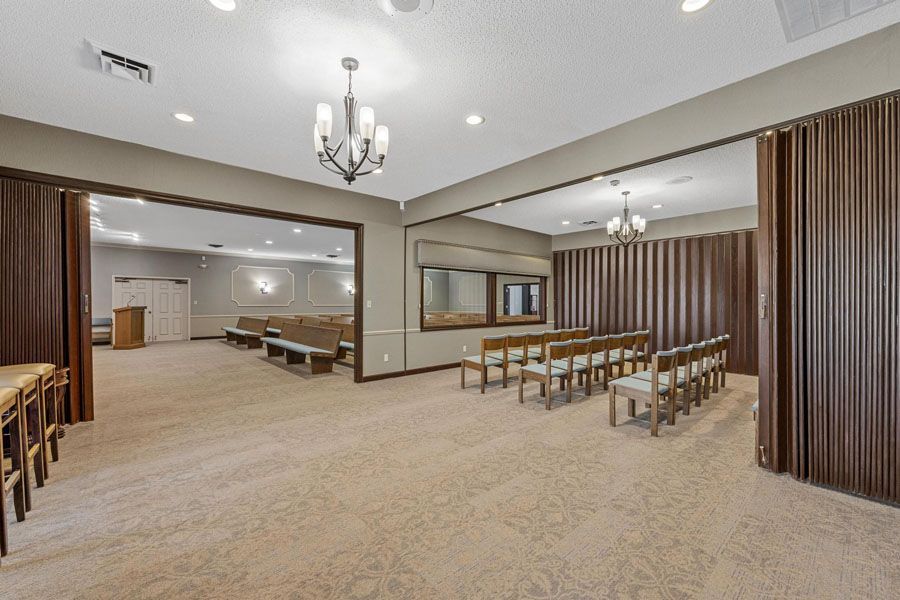 A large room with a lot of chairs and a chandelier.