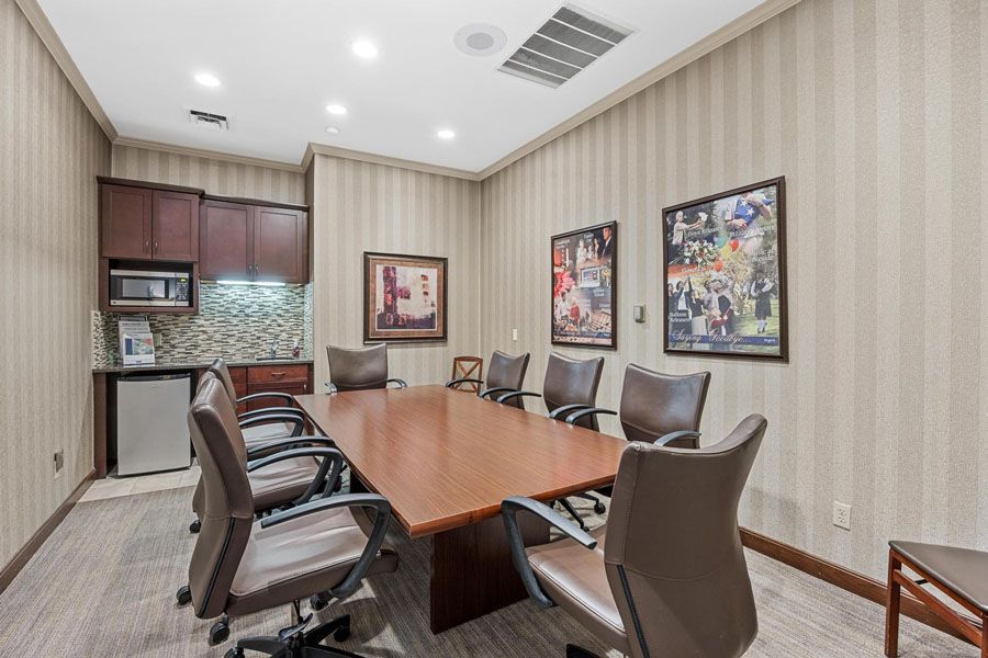 A conference room with a long table and chairs.