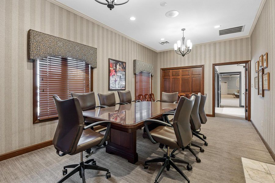A conference room with a long table and chairs.