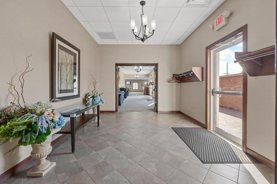 A hallway with a table and a vase of flowers in it.
