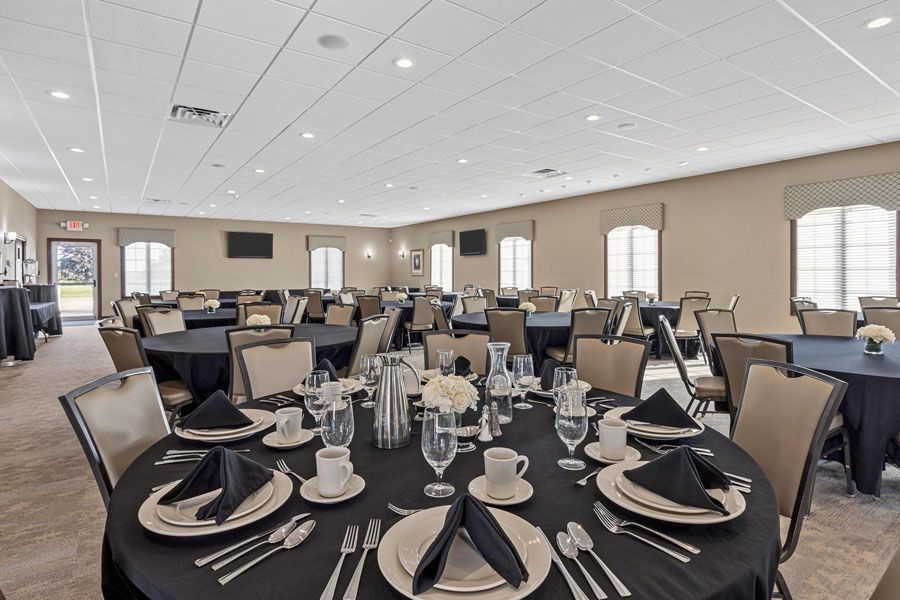 A large room with tables and chairs set up for a banquet.
