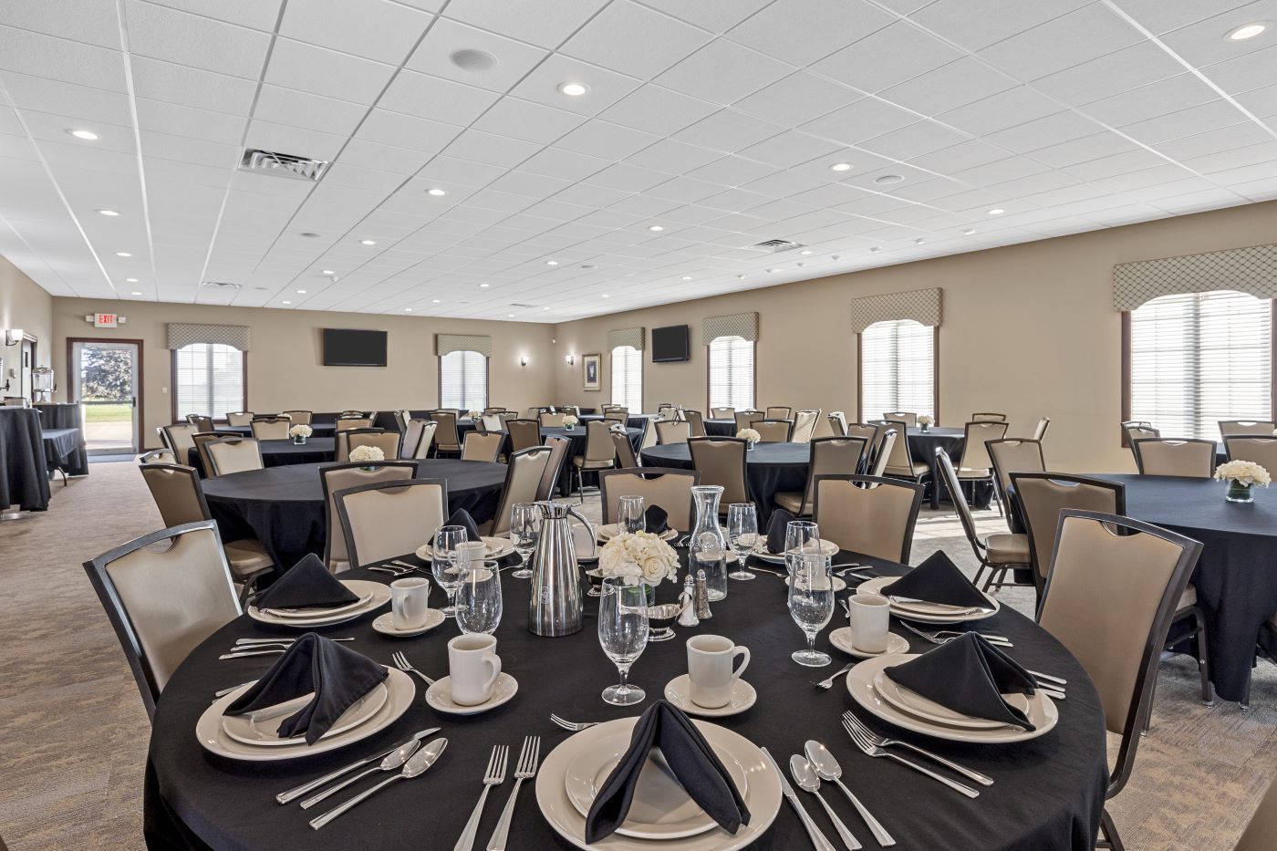 A large room with tables and chairs set up for a banquet