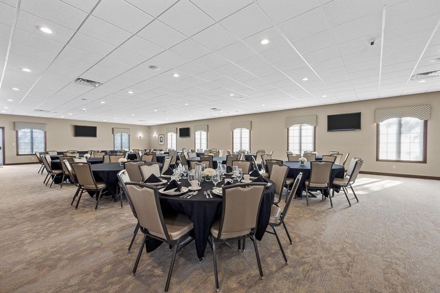 A large room with tables and chairs set up for a banquet.