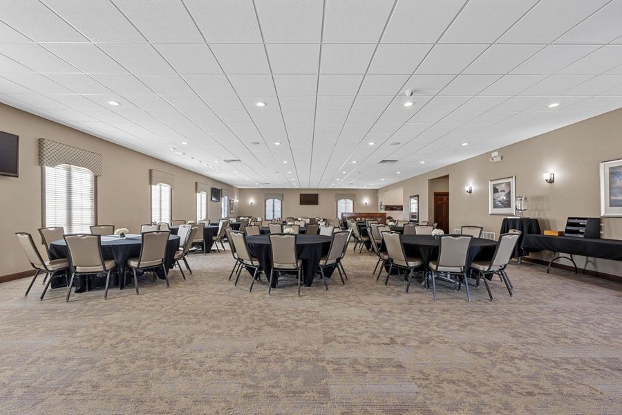 A large room with tables and chairs set up for a banquet.