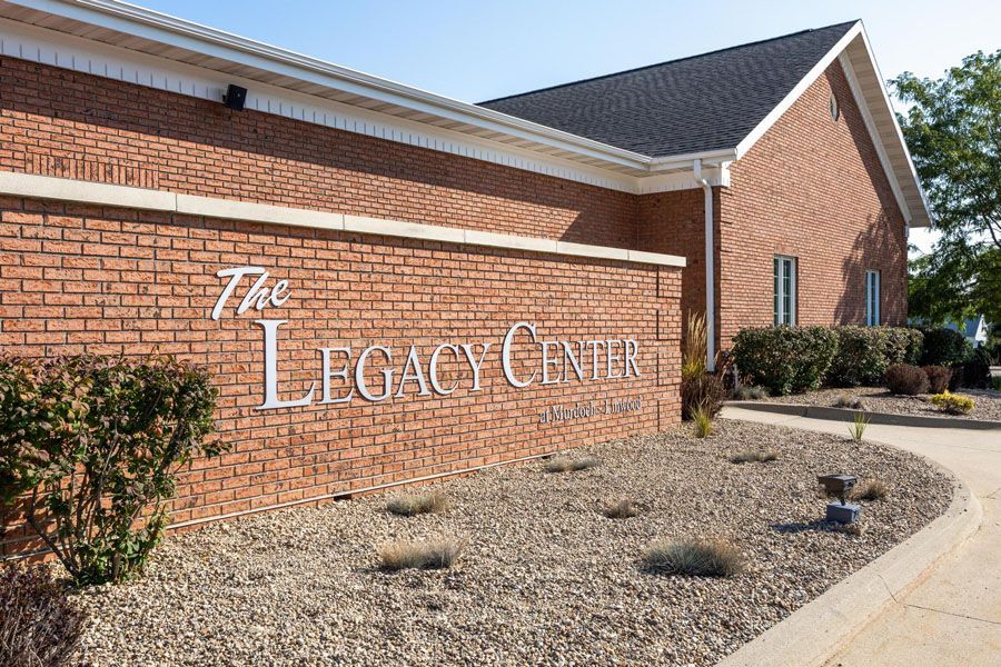 A brick building with a sign that says the legacy center