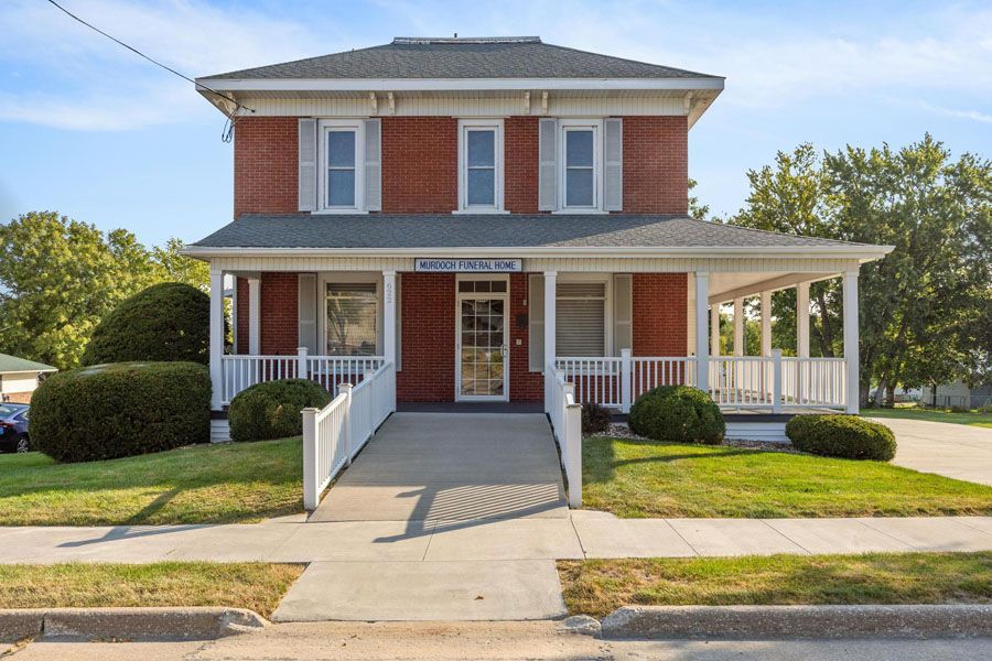 A large red brick house with a handicap ramp leading to the front door.