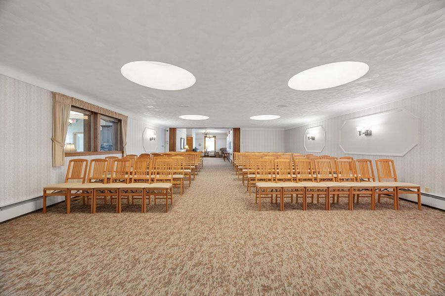 A large room with rows of chairs and tables in it.