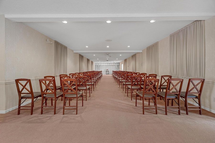 A long hallway with rows of chairs in a church.