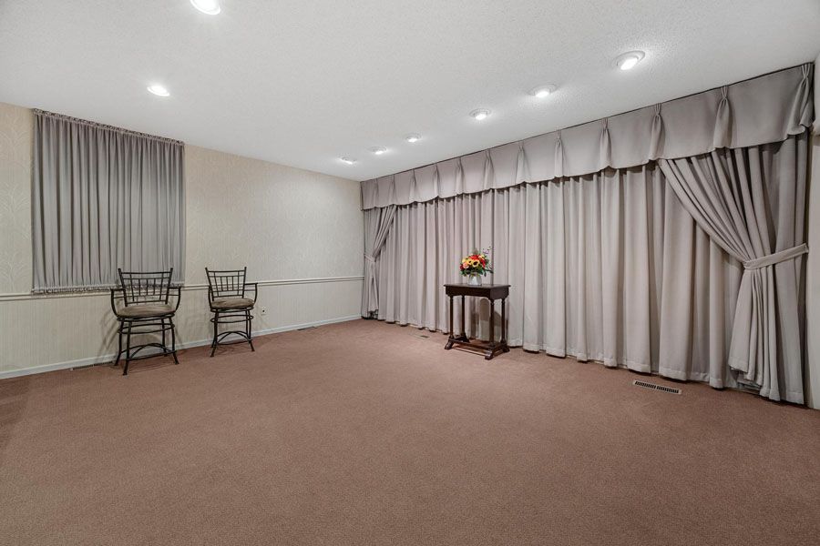 There is a table in the middle of the room with chairs.