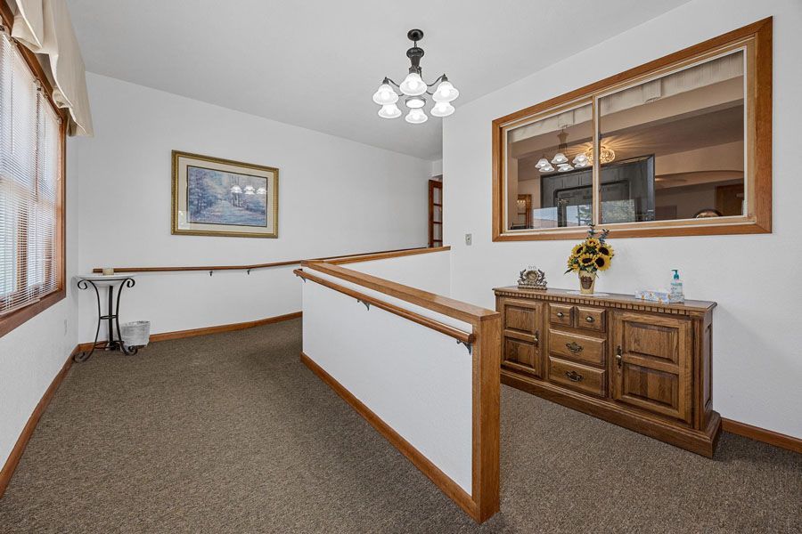 A hallway with a dresser and a picture on the wall.
