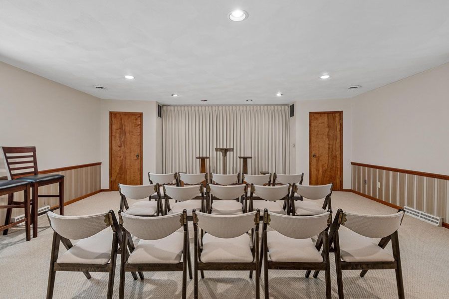 A large room with a couch and chairs in it.