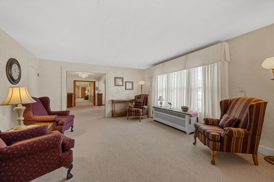 A living room filled with furniture and a clock on the wall.