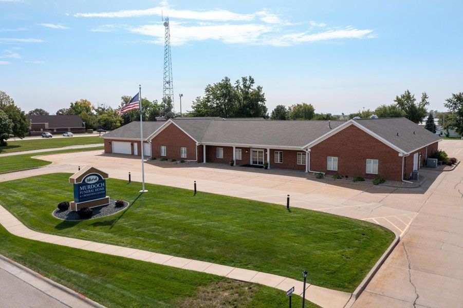 An aerial view of a brick building with a large lawn in front of it.