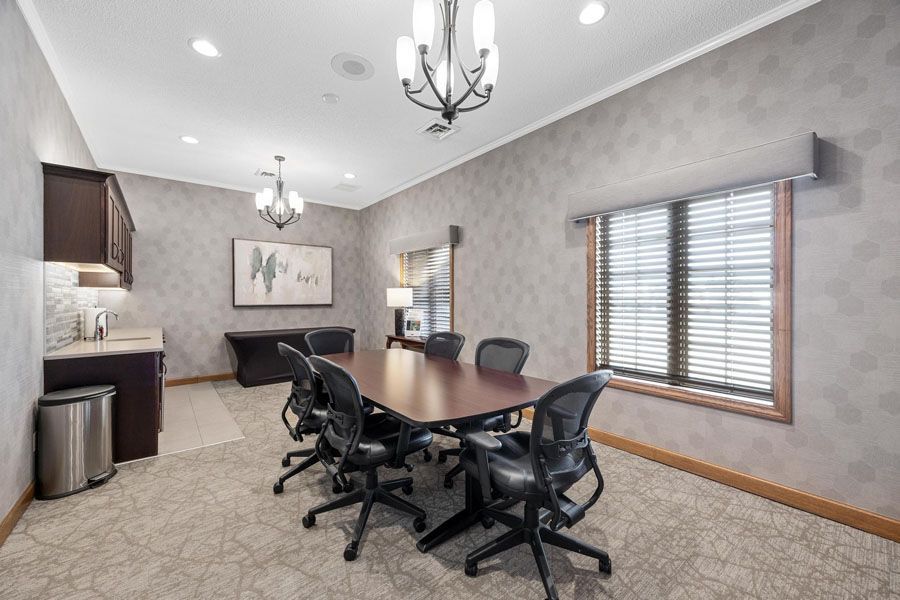 A conference room with a table and chairs and a chandelier.
