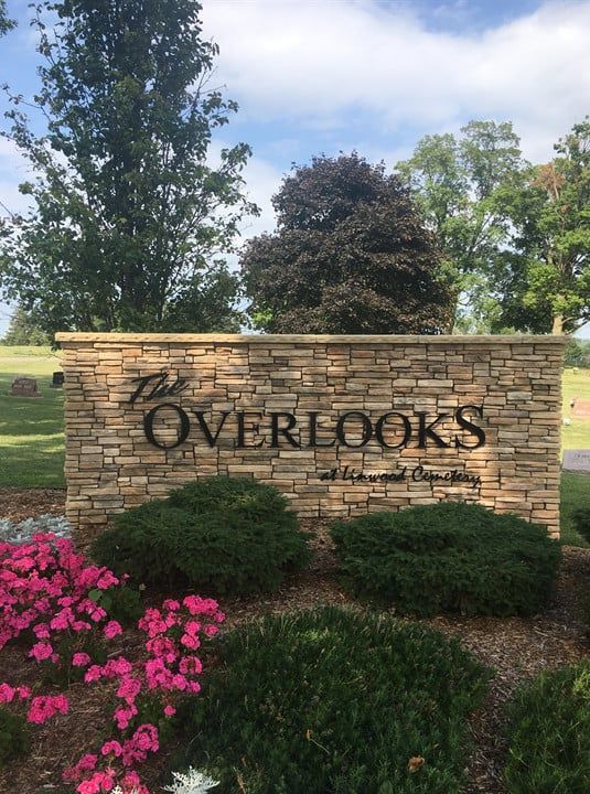 A sign for the overlooks is surrounded by flowers and bushes