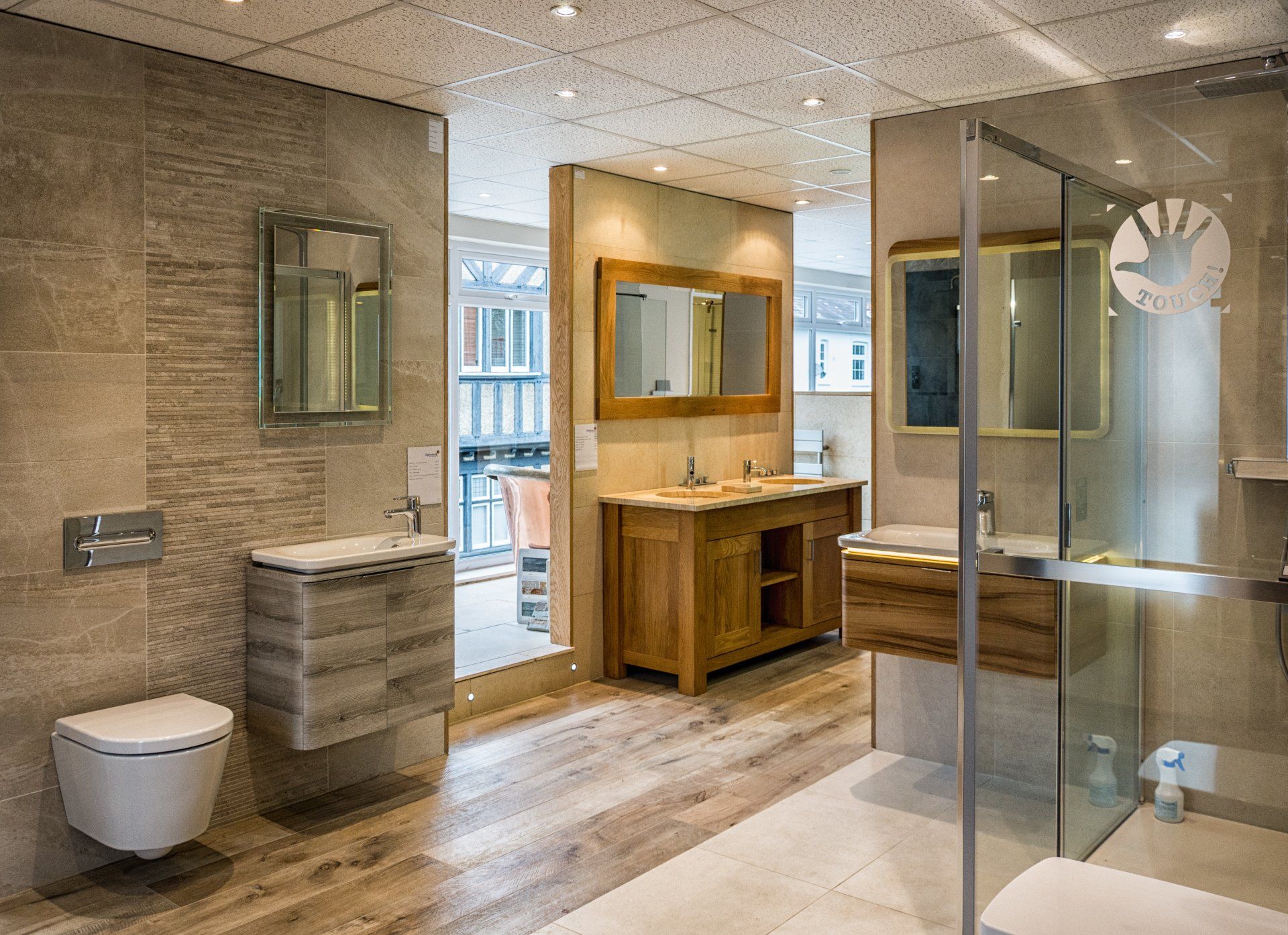 A bathroom with two sinks , a toilet , and a walk in shower.