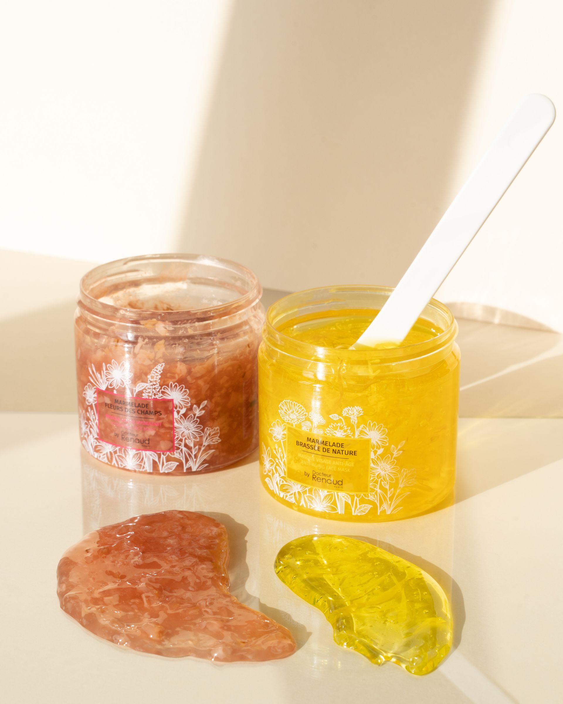 Twee potten scrub en een lepel op een tafel.