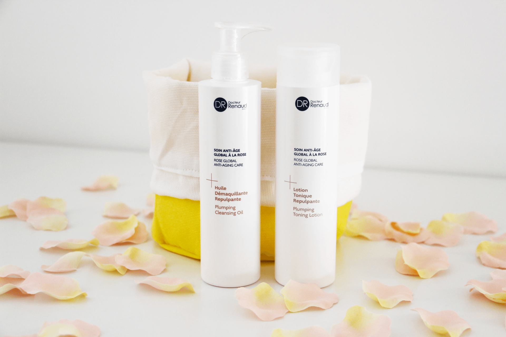 Twee flessen shampoo en conditioner staan ​​op een tafel, omringd door rozenblaadjes.