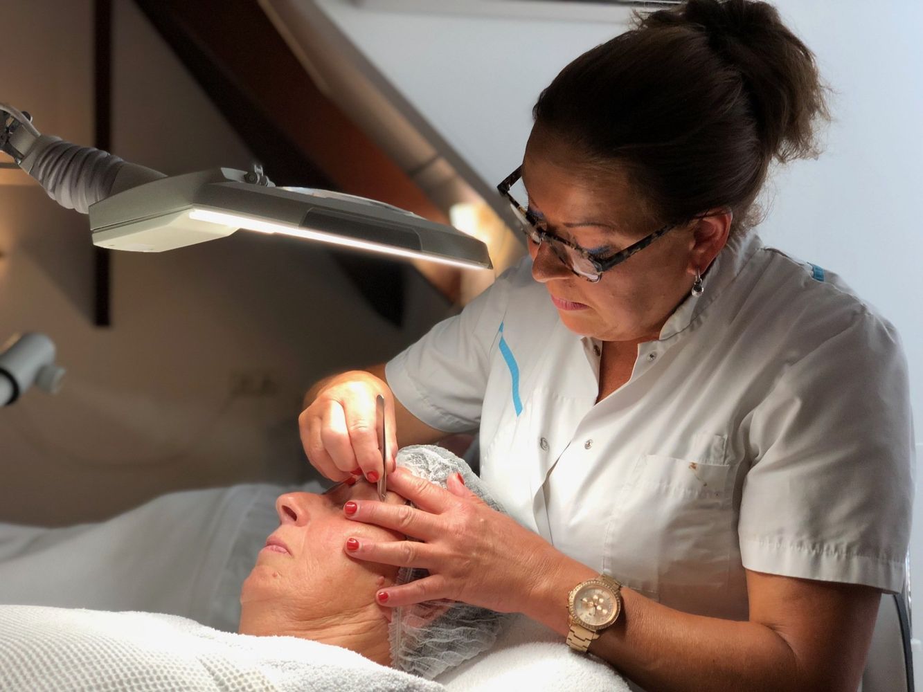 Een vrouw bekijkt het gezicht van een vrouw onder een vergrootglas.