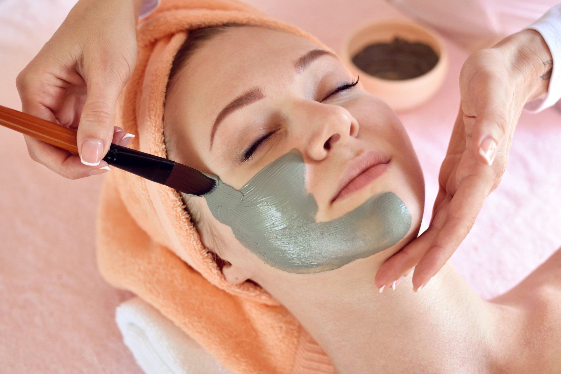 Een vrouw krijgt een gezichtsbehandeling in een spa.