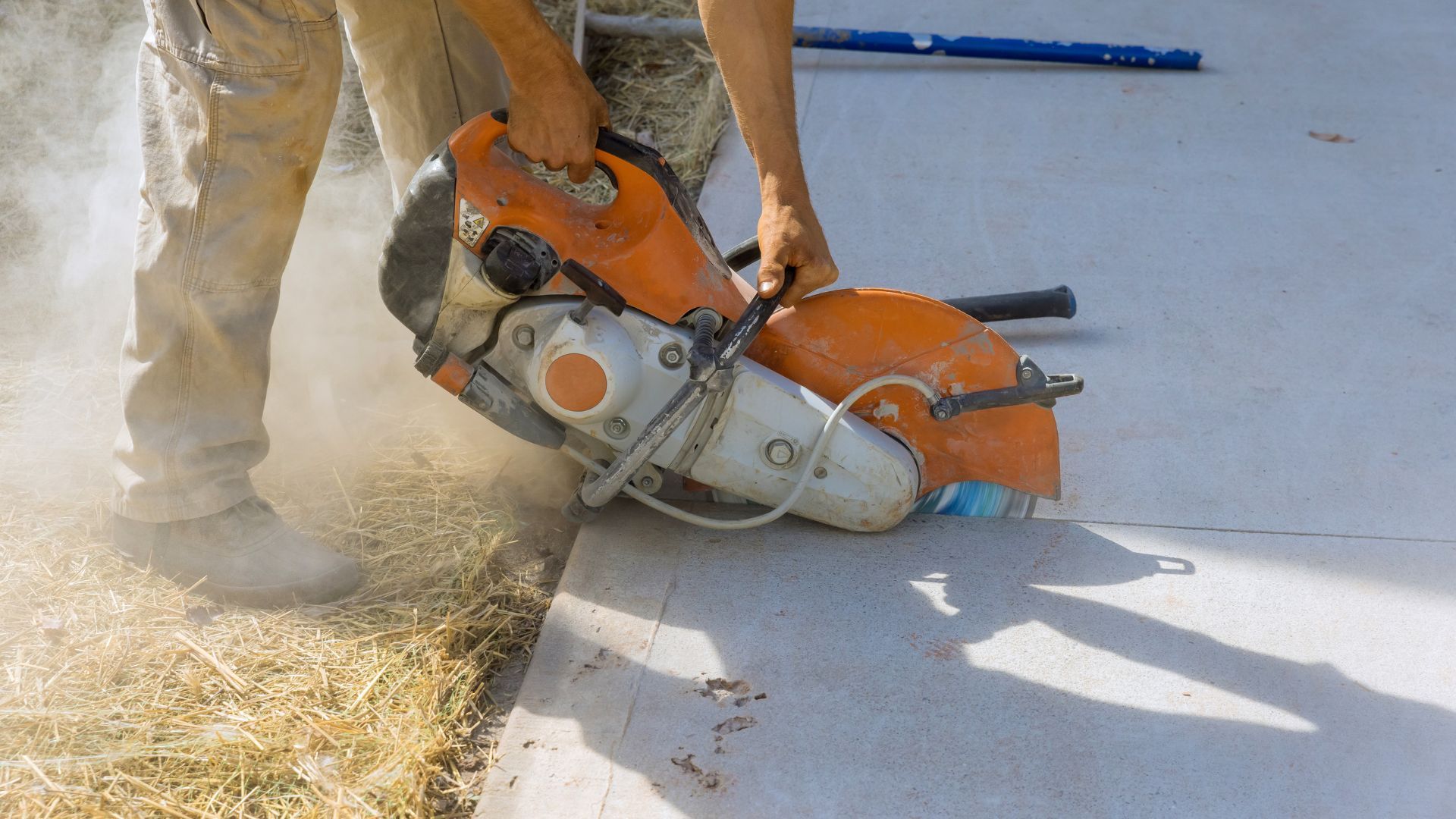 A man is cutting concrete with a circular saw.