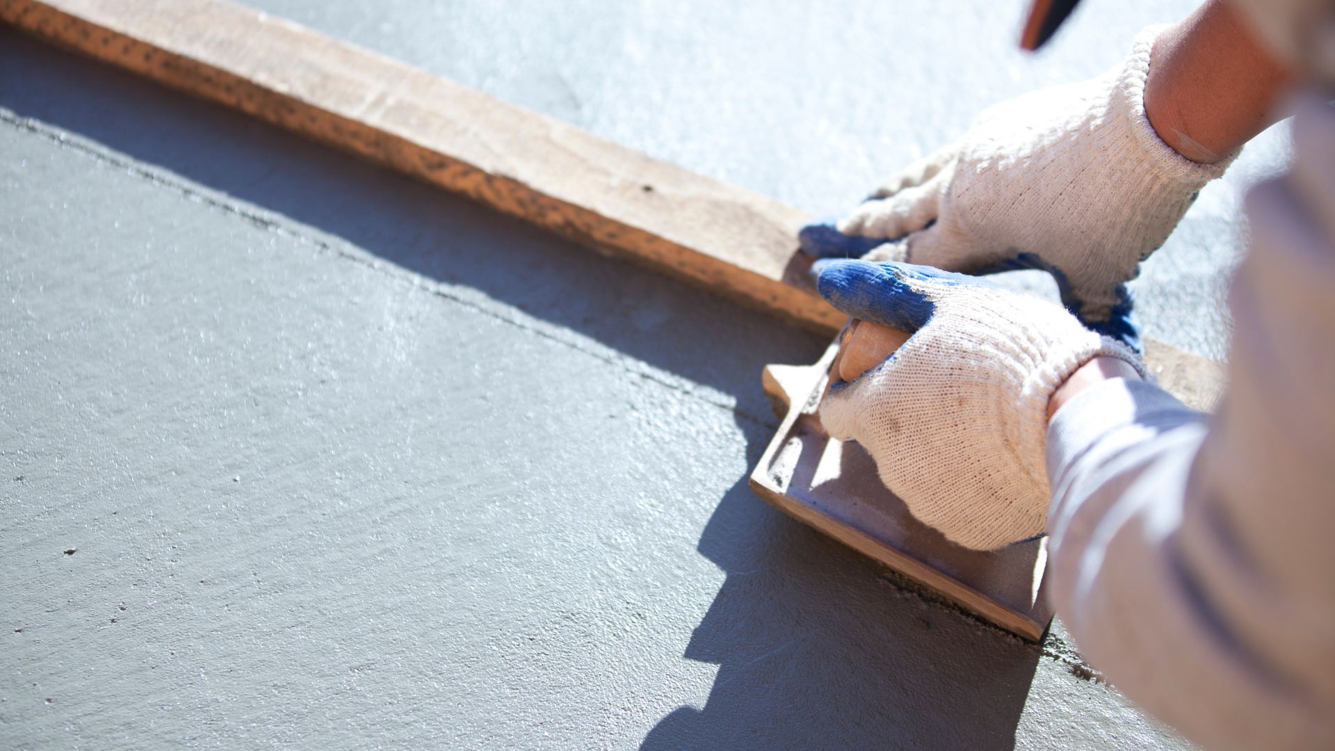 A person is using a trowel on a concrete surface.