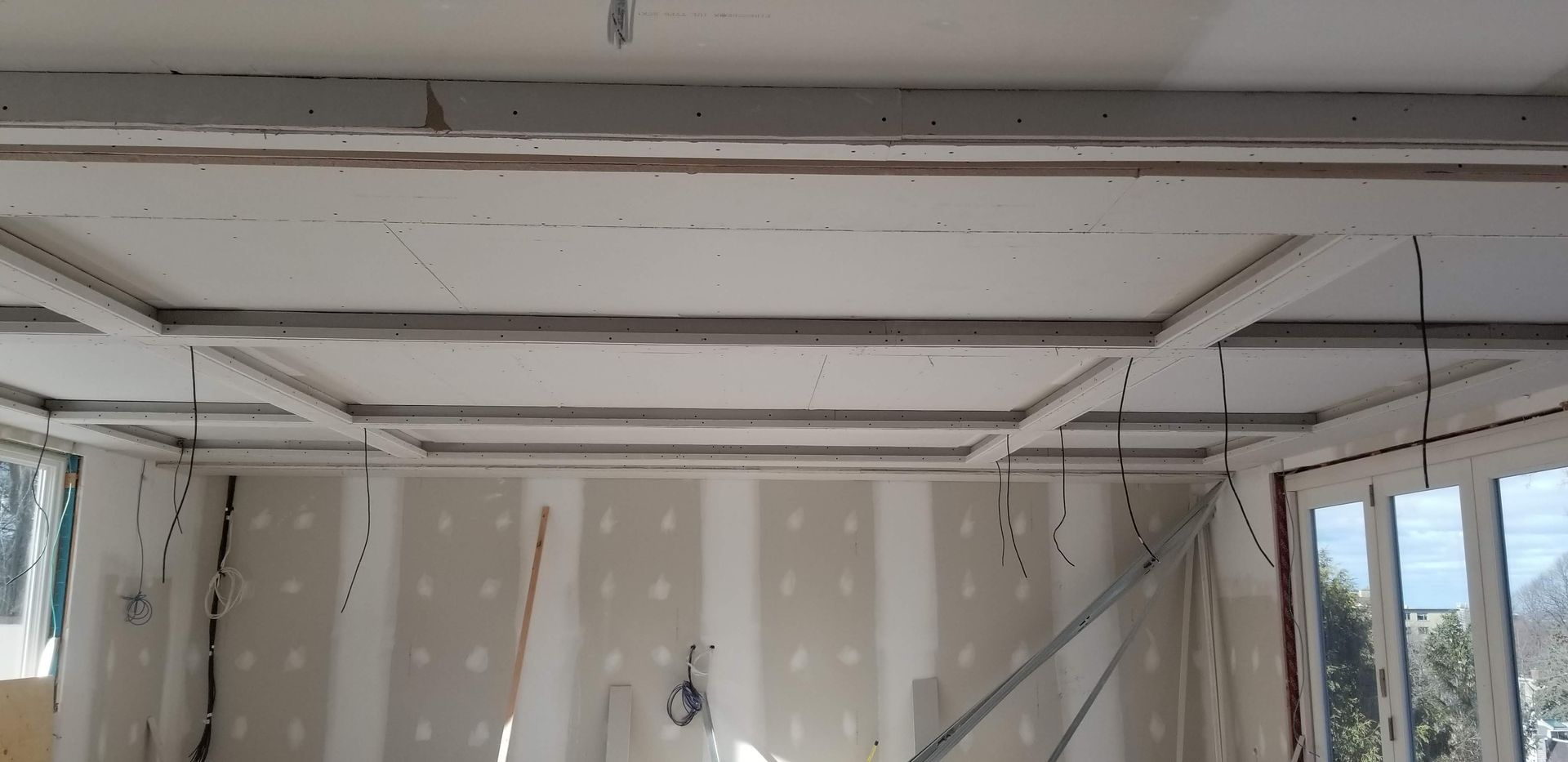 Une pièce avec un plafond en cours de construction et de nombreuses fenêtres.
