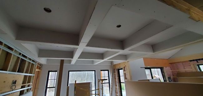 Une pièce avec un plafond en cours de construction et de nombreuses fenêtres.