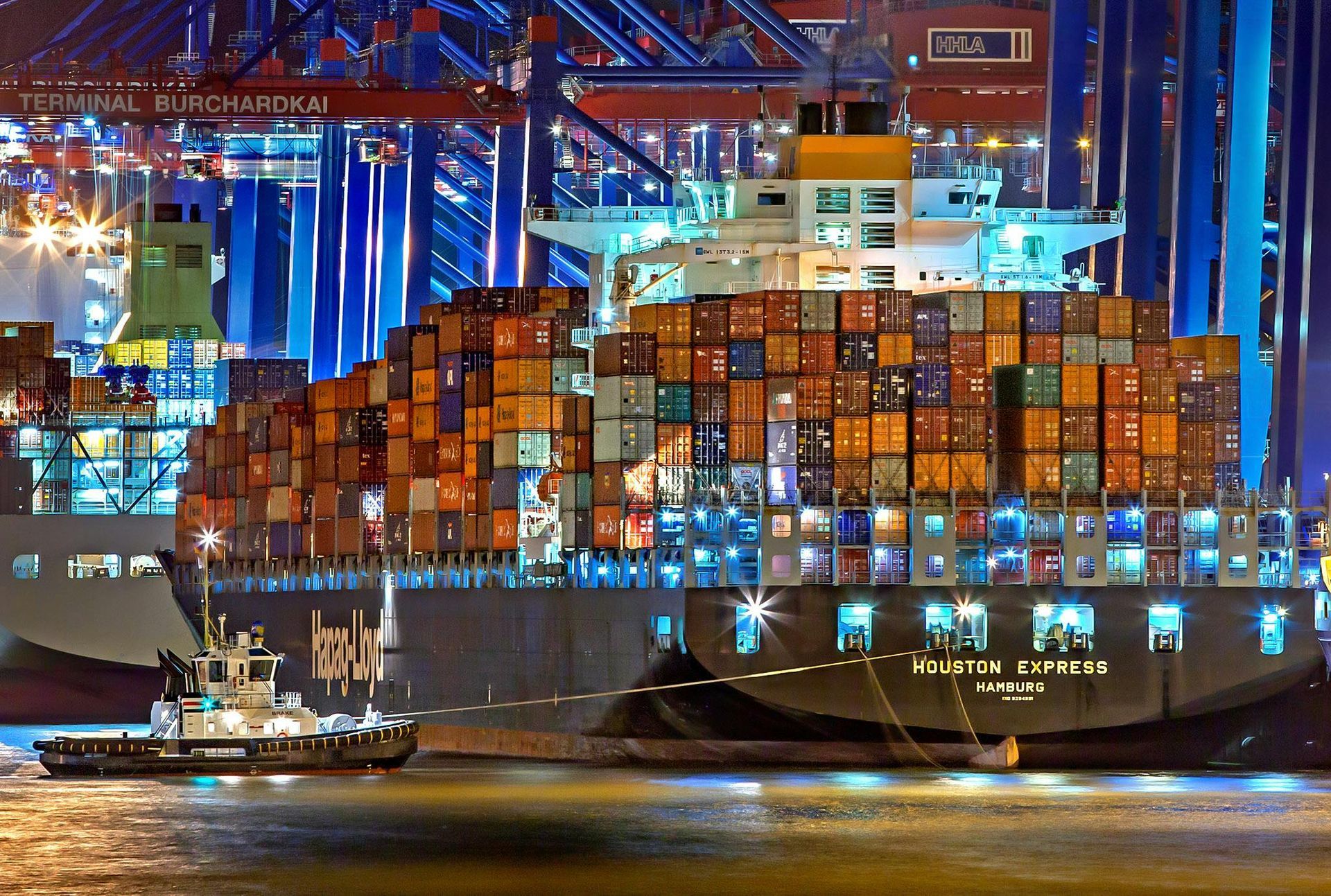 container ship moored in port at night, illustrating supply‑chain and sanctions compliance risks