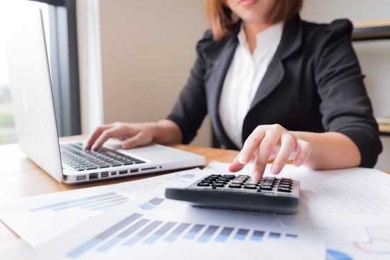 woman working on laptop and calculator
