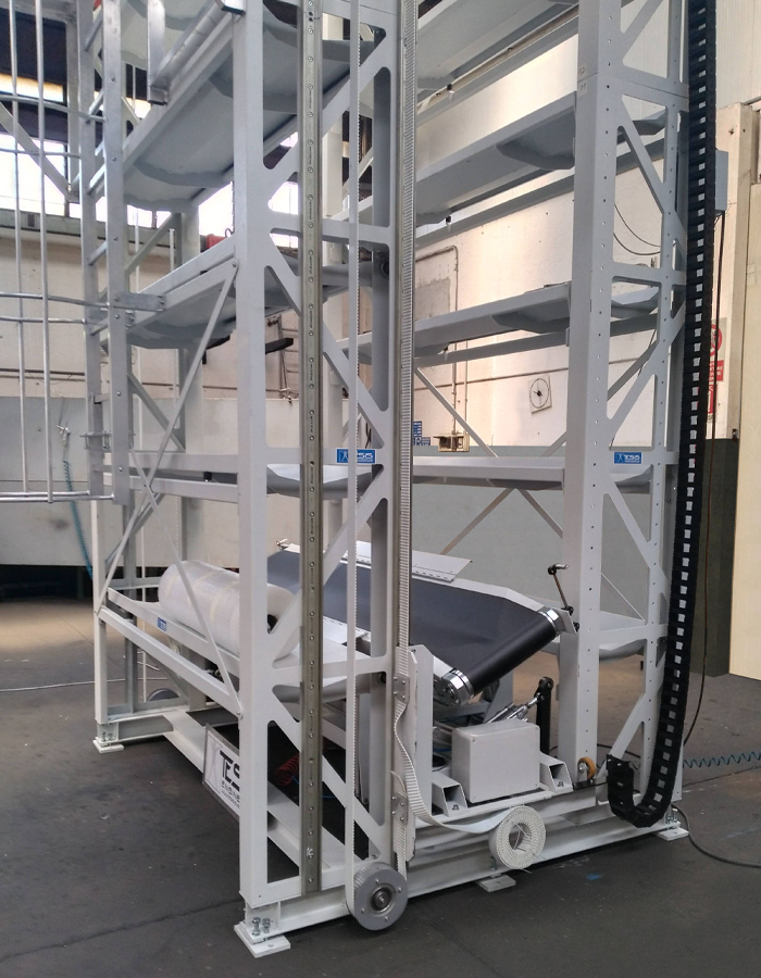 Custom engineered vertical accumulation system for rolls of fabric, rolls reels and coils handling equipment