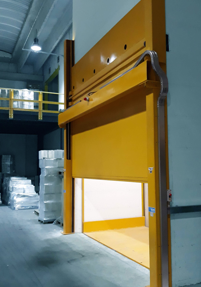 Scissor cargo lift in enclosed shaft for moving goods between different levels of an industrial building, vertical fixed goods elevator with scissor lift, multiple scissor freight lift