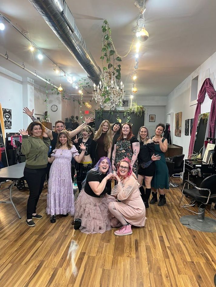 A group of women are posing for a picture in a salon.