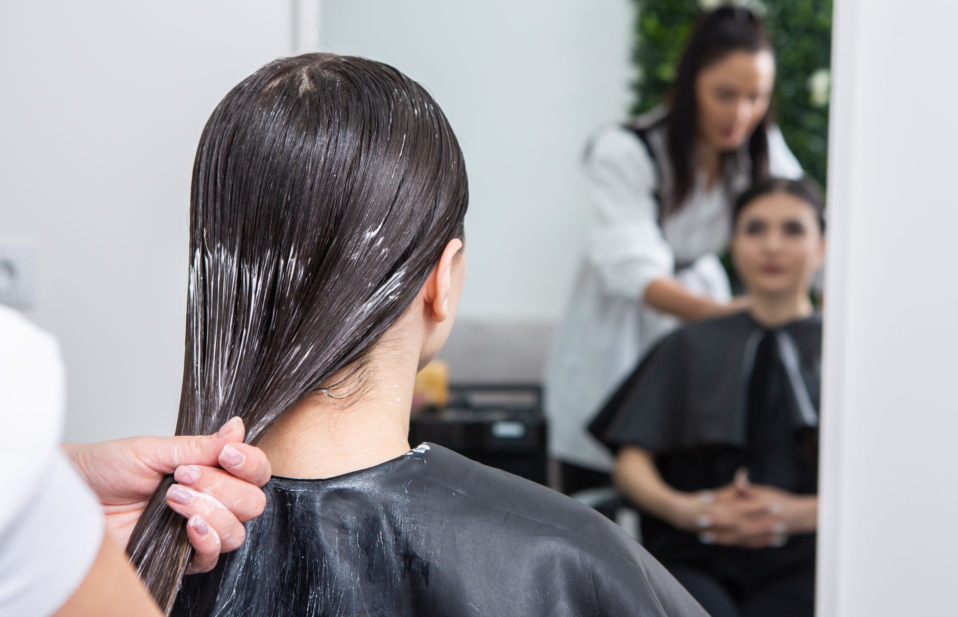 A woman is getting her hair dyed in a salon.