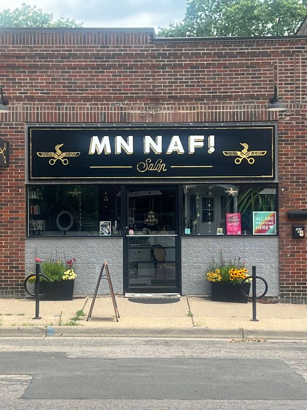 The front of a brick building with a sign that says mn naf !