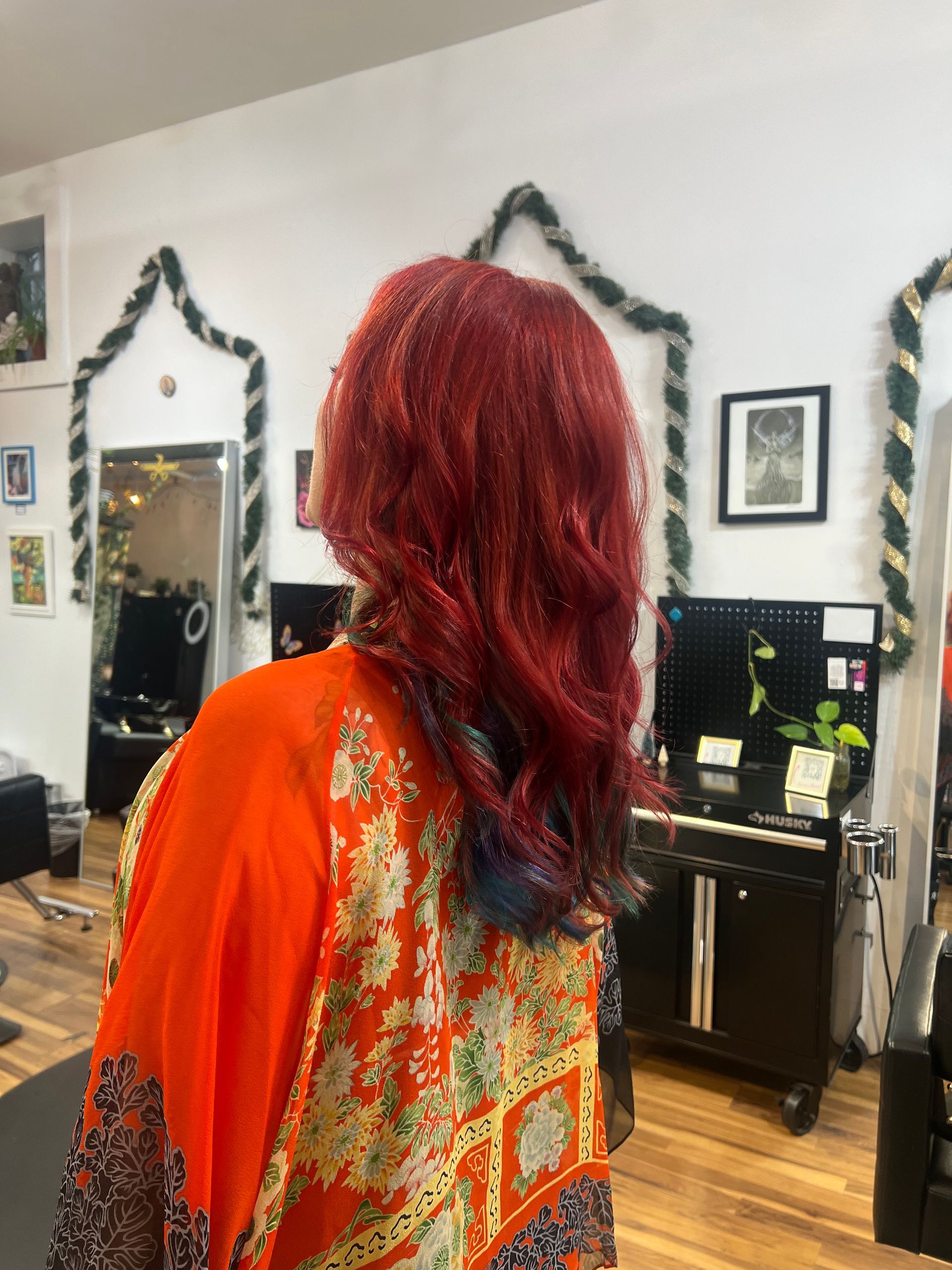 A woman with red hair is standing in a salon.